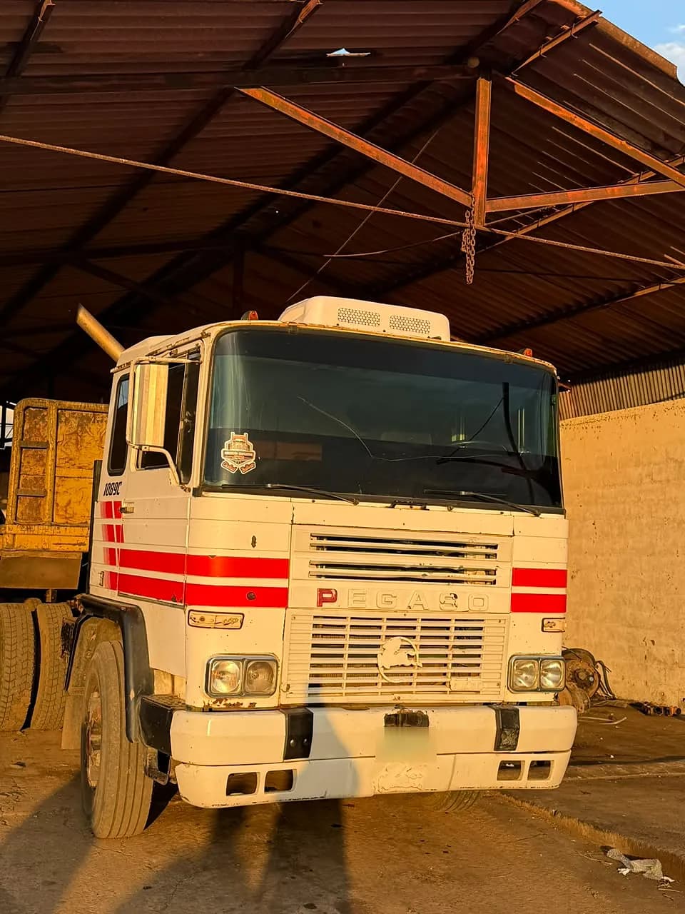 Pegaso 1089 blanco con franjas rojas dentro de un galpón