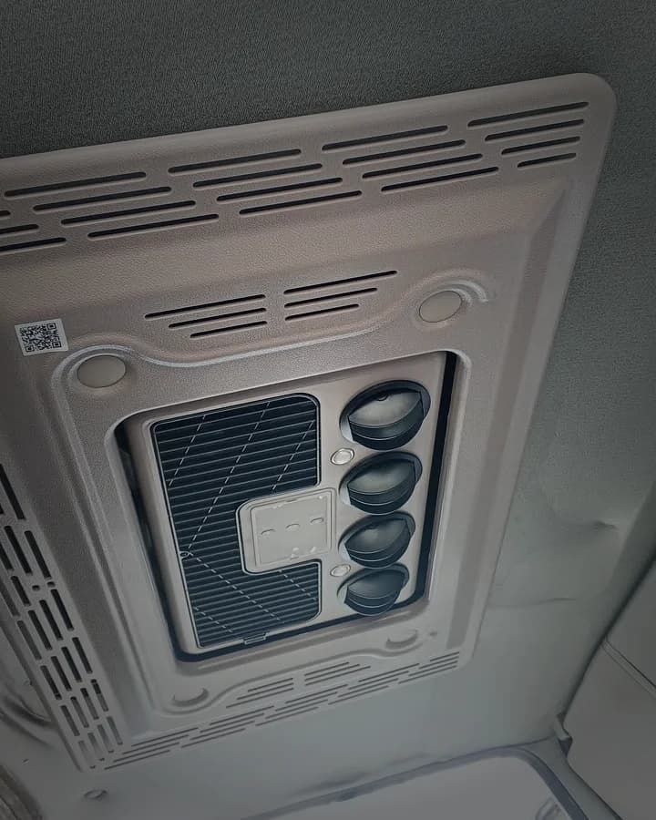 Consola del aire acondicionado en el techo interior de la cabina, con rejillas negras orientables